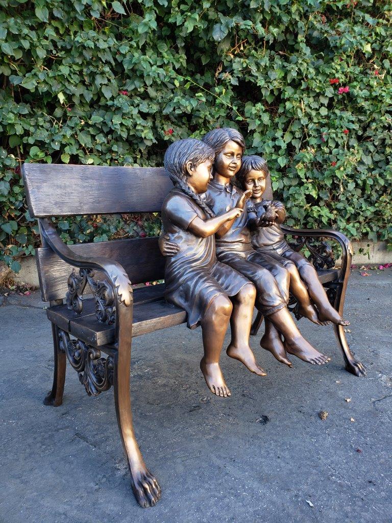 Three kids on a Bench Holding a Bird Bronze Statue - Size: 40"L x 30"W x 33"H.