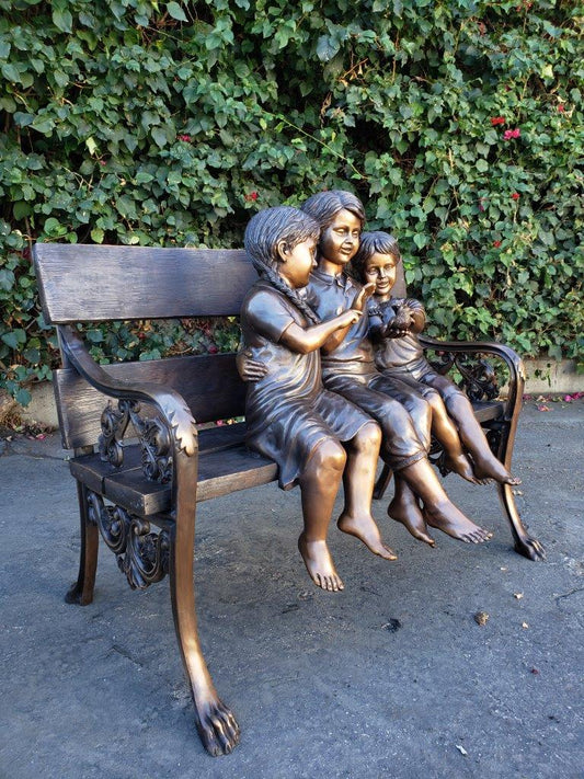 Three kids on a Bench Holding a Bird Bronze Statue - Size: 40"L x 30"W x 33"H.