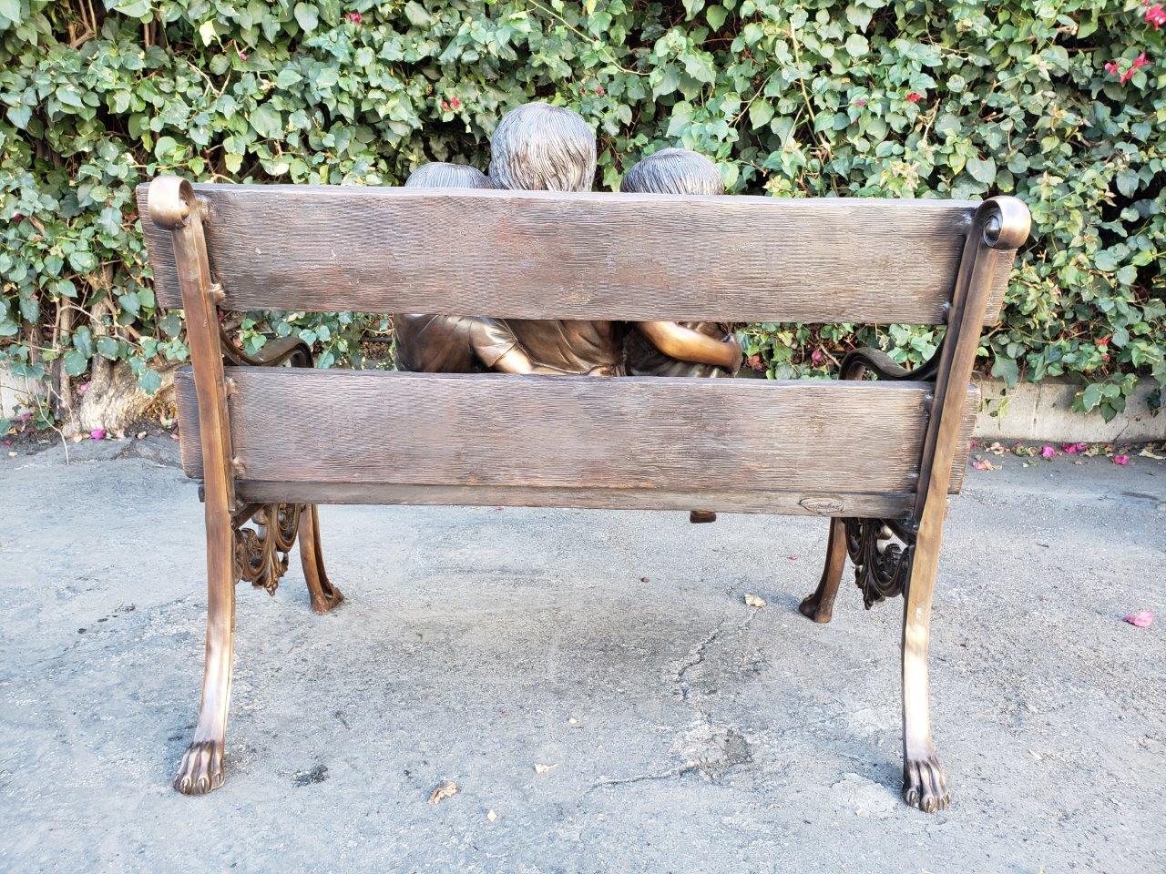 Three kids on a Bench Holding a Bird Bronze Statue - Size: 40"L x 30"W x 33"H.
