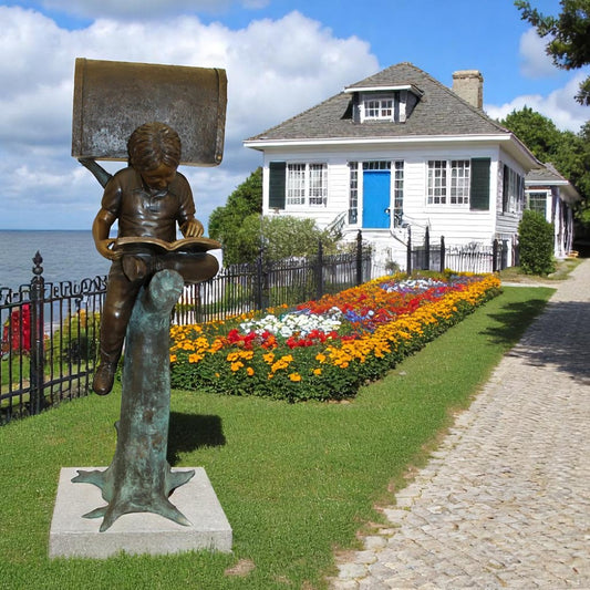 Boy Sitting by a Mailbox reading a book Bronze Statue -  16"L x 20"W x 50"H.