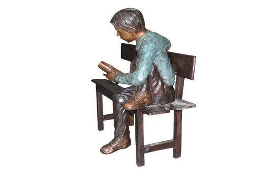 boy Sitting on a Bench reading book bronze Statue - Size: 43"L x 20"W x 36"H.