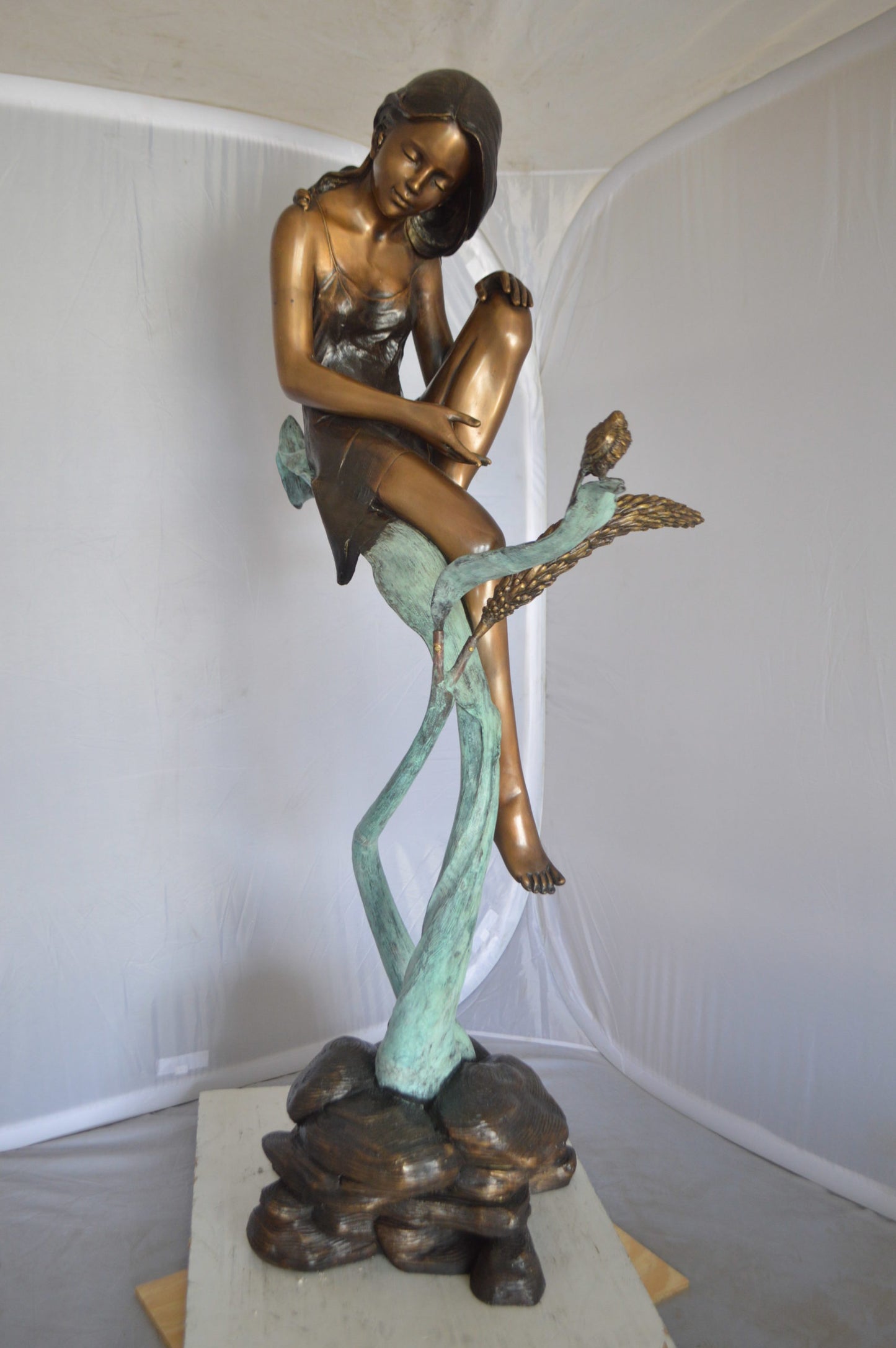Beautiful Young Girl Sitting on a Tree Bronze Statue - 35"L x 50"W x 55"H.
