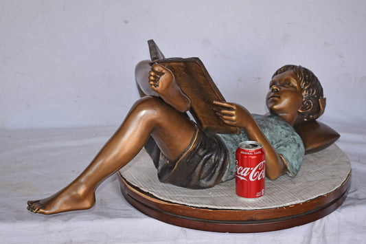 Kid on A Pillow Reading a Book Bronze Statue - Size: 32"L x 13"W x 12"H.