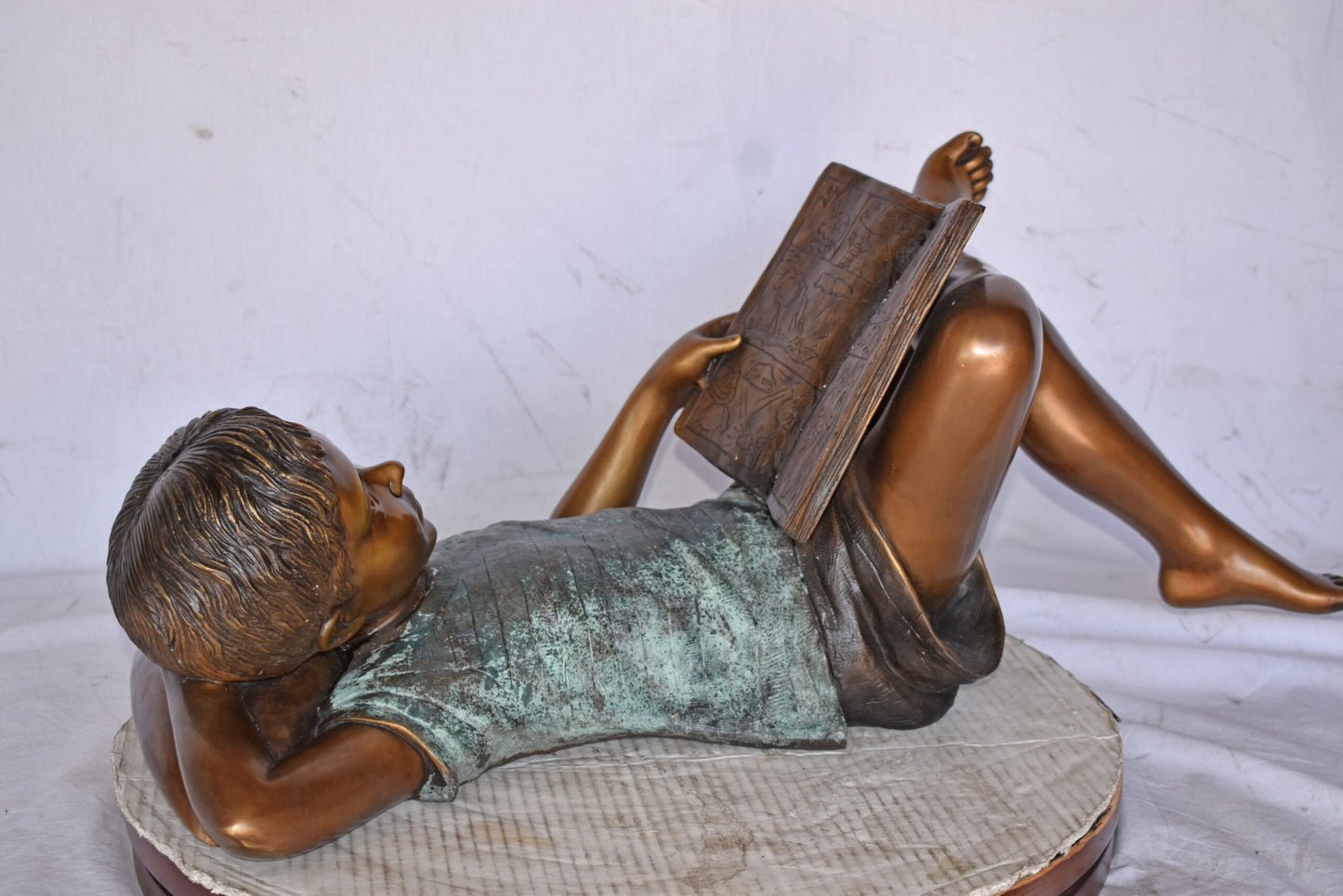 Kid on A Pillow Reading a Book Bronze Statue - Size: 32"L x 13"W x 12"H.