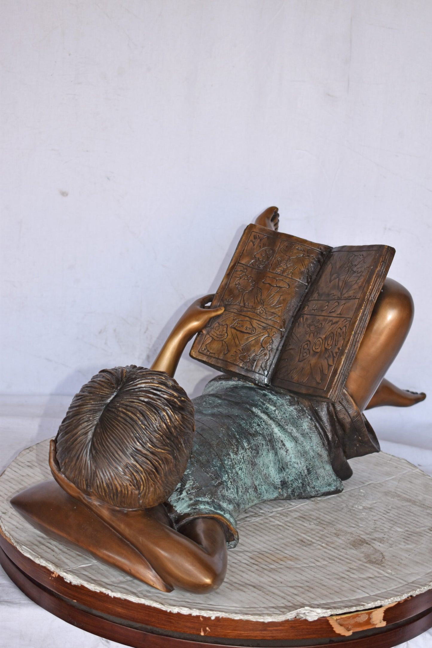Kid on A Pillow Reading a Book Bronze Statue - Size: 32"L x 13"W x 12"H.