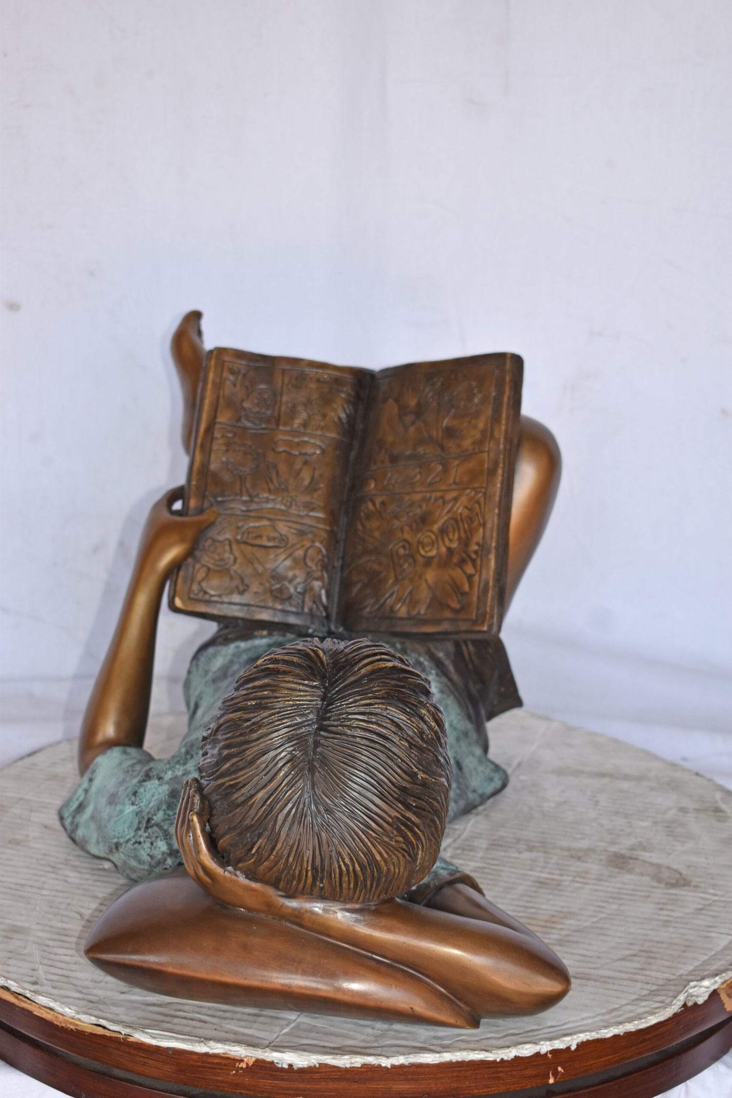 Kid on A Pillow Reading a Book Bronze Statue - Size: 32"L x 13"W x 12"H.