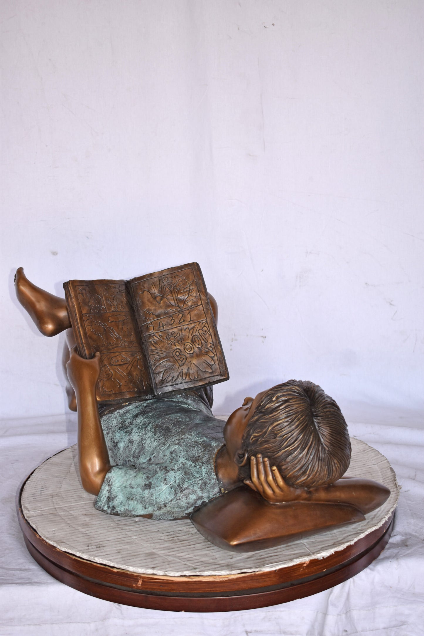 Kid on A Pillow Reading a Book Bronze Statue - Size: 32"L x 13"W x 12"H.