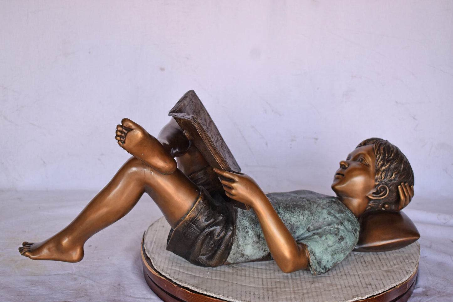 Kid on A Pillow Reading a Book Bronze Statue - Size: 32"L x 13"W x 12"H.