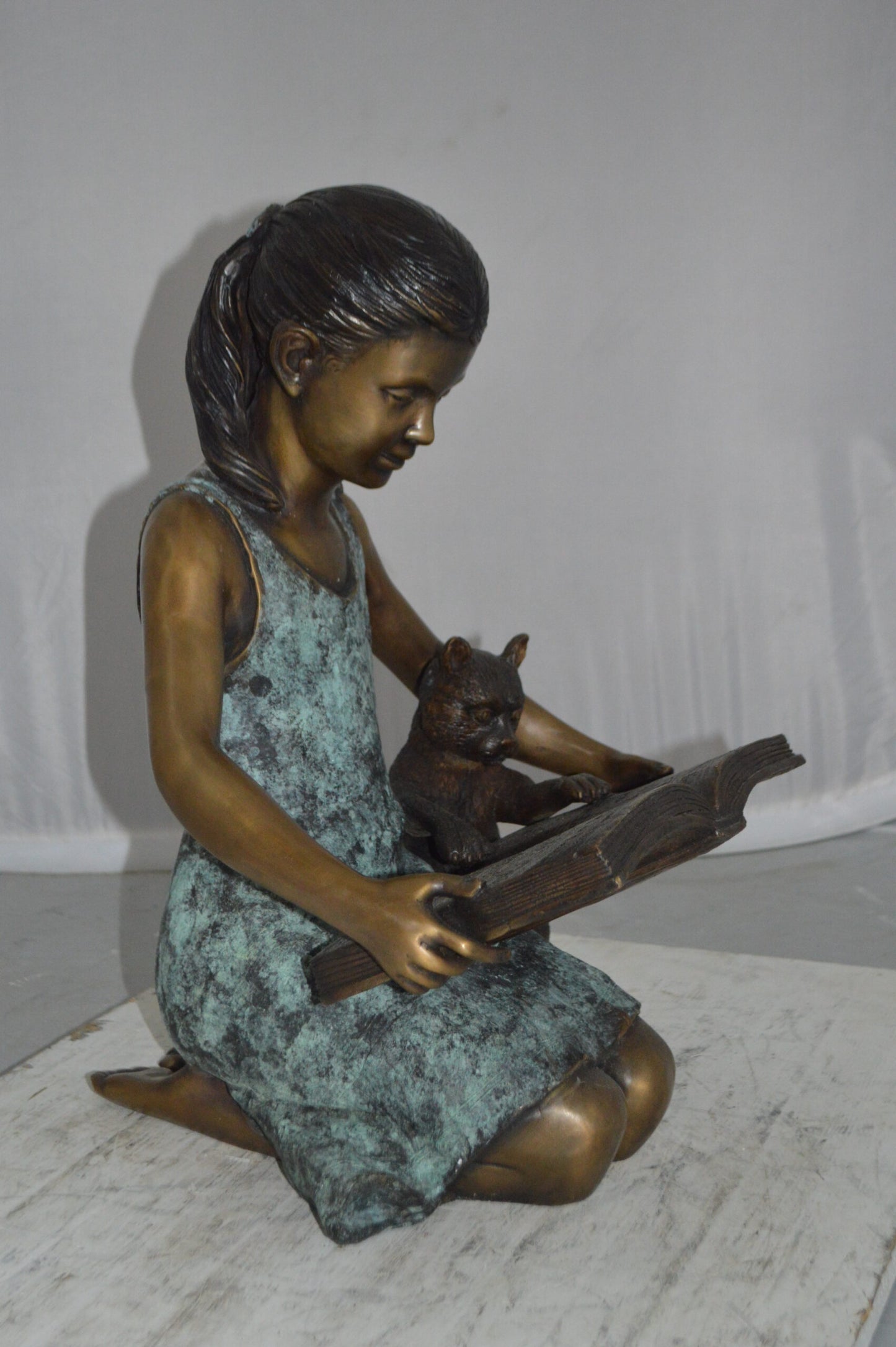 Girl and her dog reading a book Bronze Statue -  Size: 20"L x 8"W x 14"H.