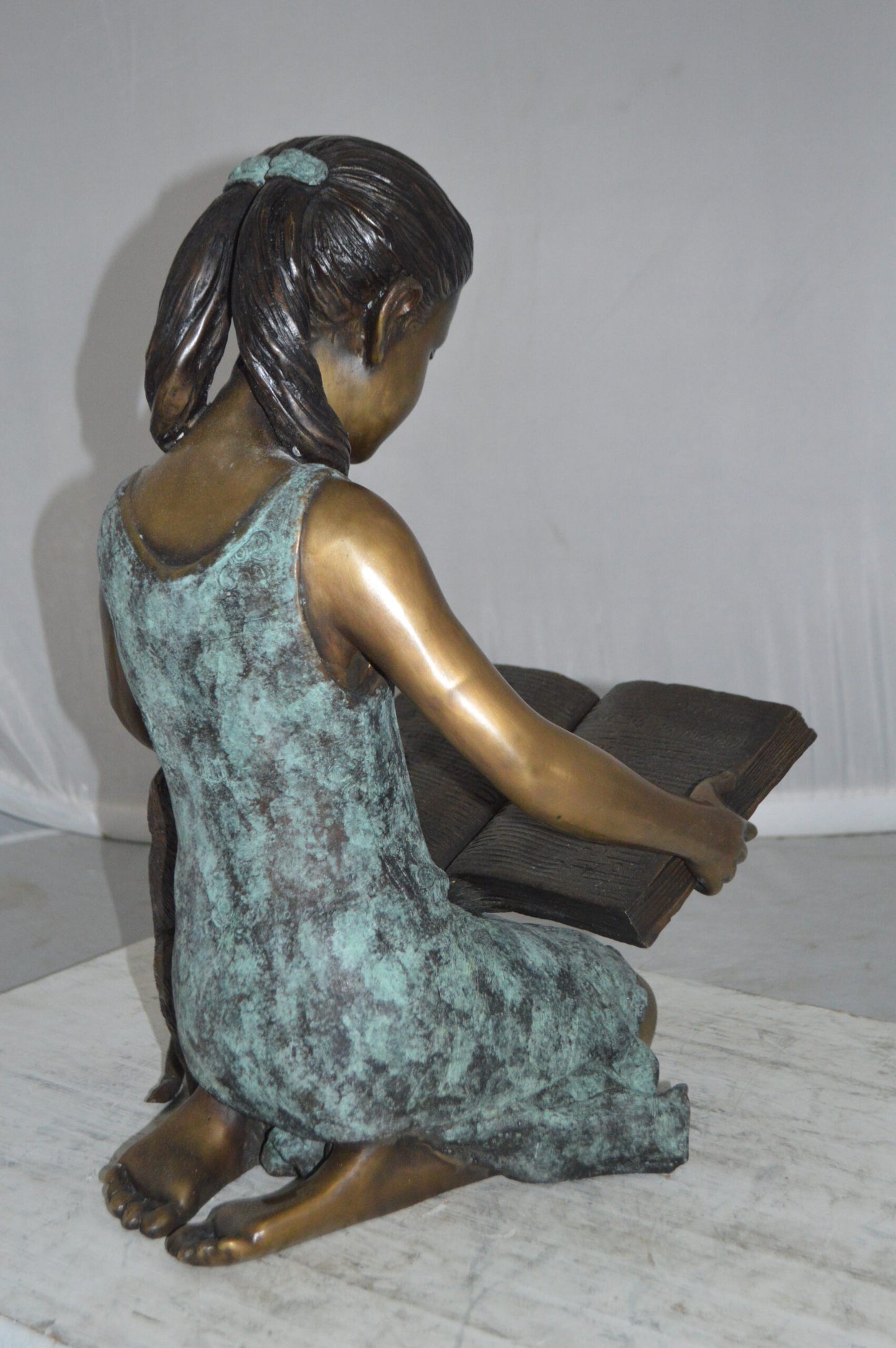 Girl and her dog reading a book Bronze Statue -  Size: 20"L x 8"W x 14"H.