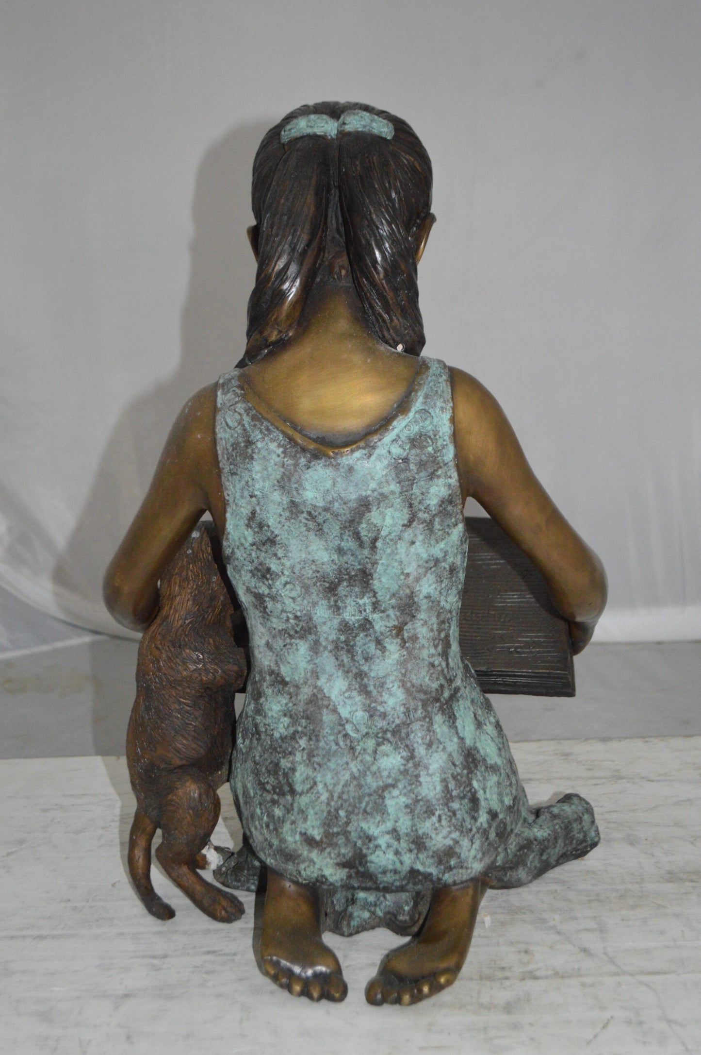 Girl and her dog reading a book Bronze Statue -  Size: 20"L x 8"W x 14"H.