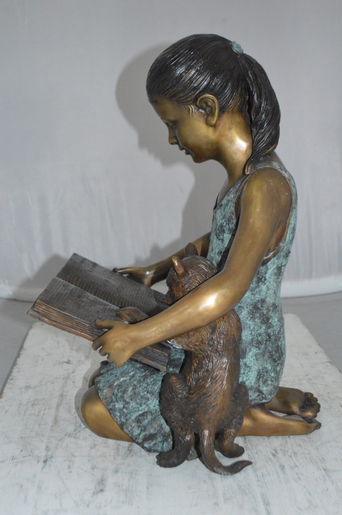 Girl and her dog reading a book Bronze Statue -  Size: 20"L x 8"W x 14"H.