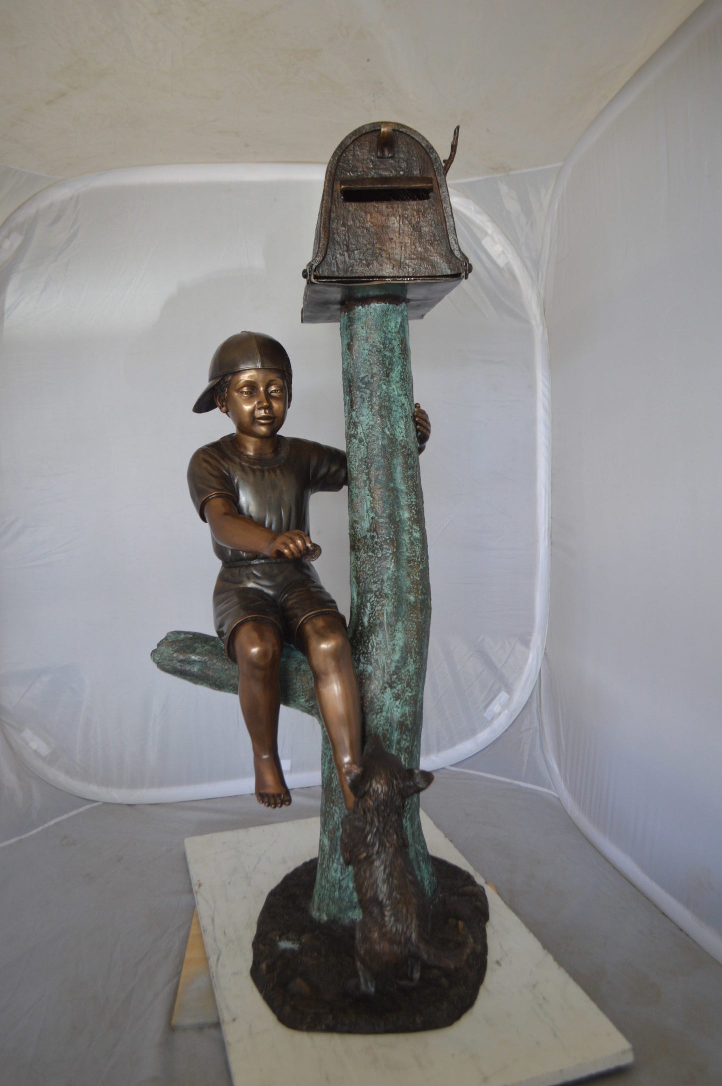 Boy Sitting on a Tree with Mailbox Bronze Statue - Size: 22"L x 23"W x 49"H.