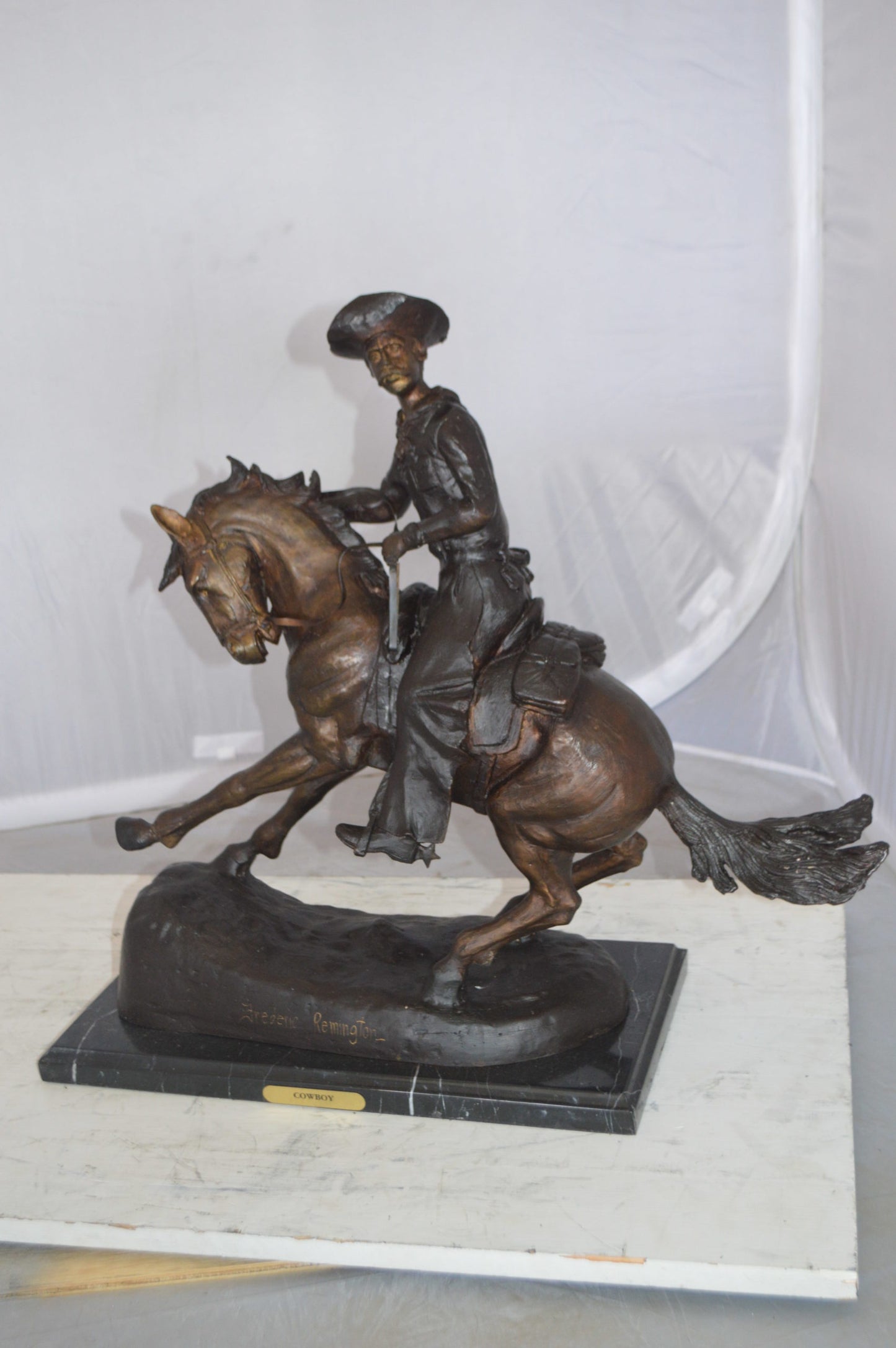 Remington Cowboy on marble Bronze Statue - Size: 24"L x 9"W x 23"H.
