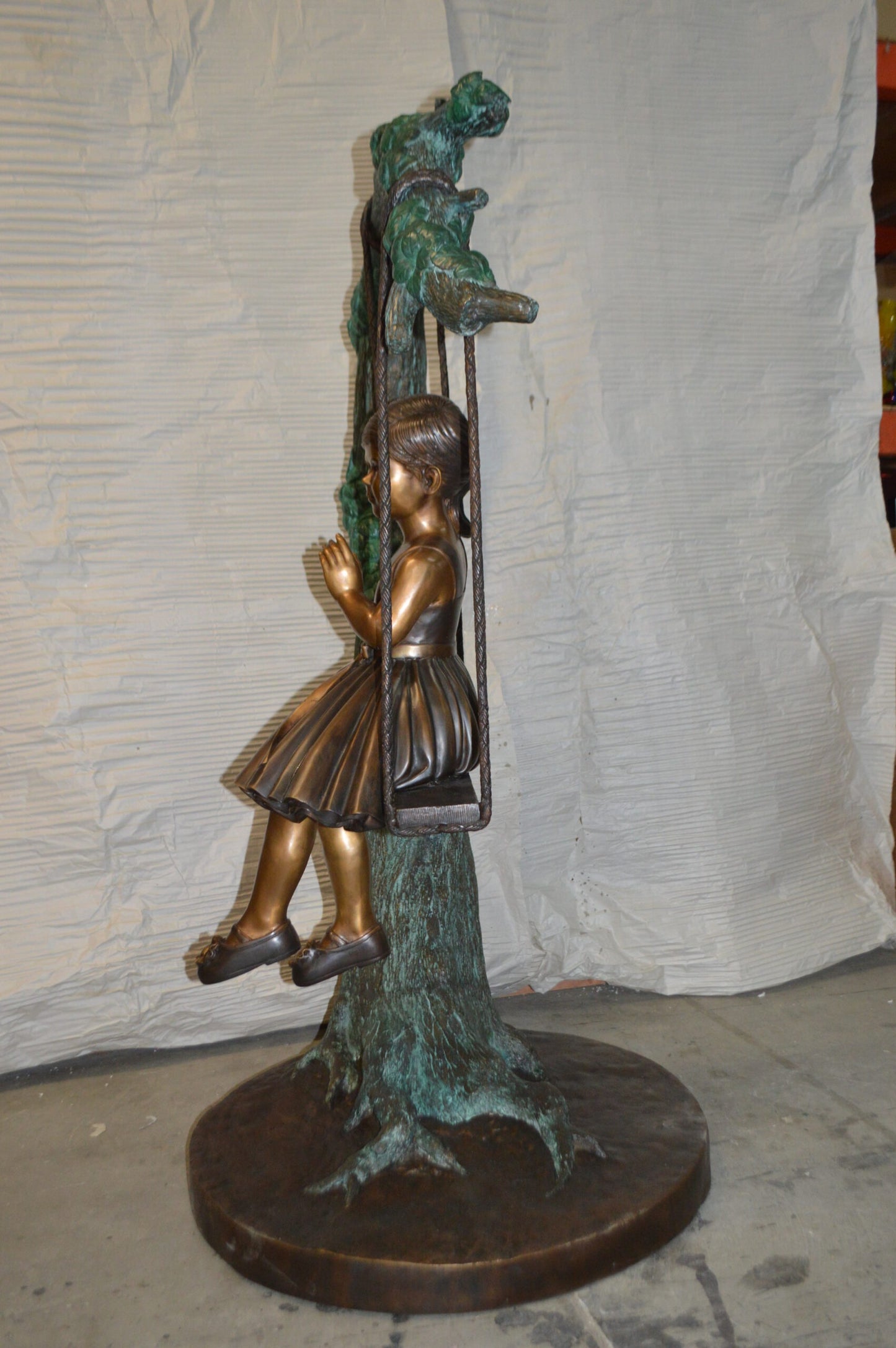 Girl on Swing 65 Bronze Statue - Size: 44"L x 35"W x 65"H.