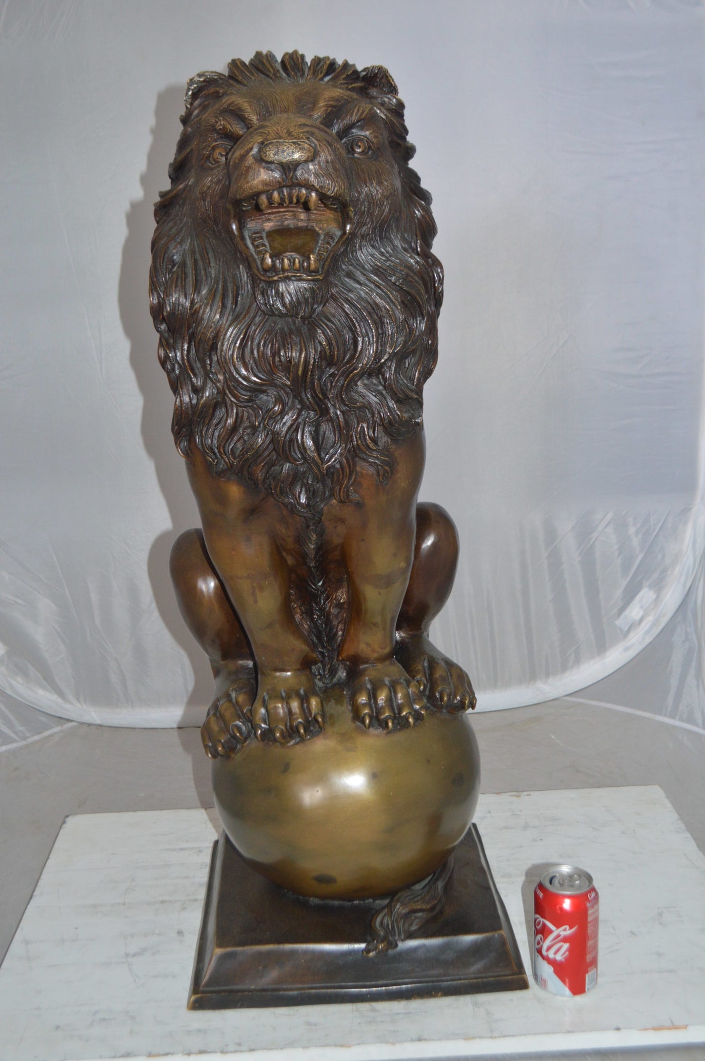 Pair of lions standing on balls, bronze statues - Size: 14"L x 16"W x 38"H.