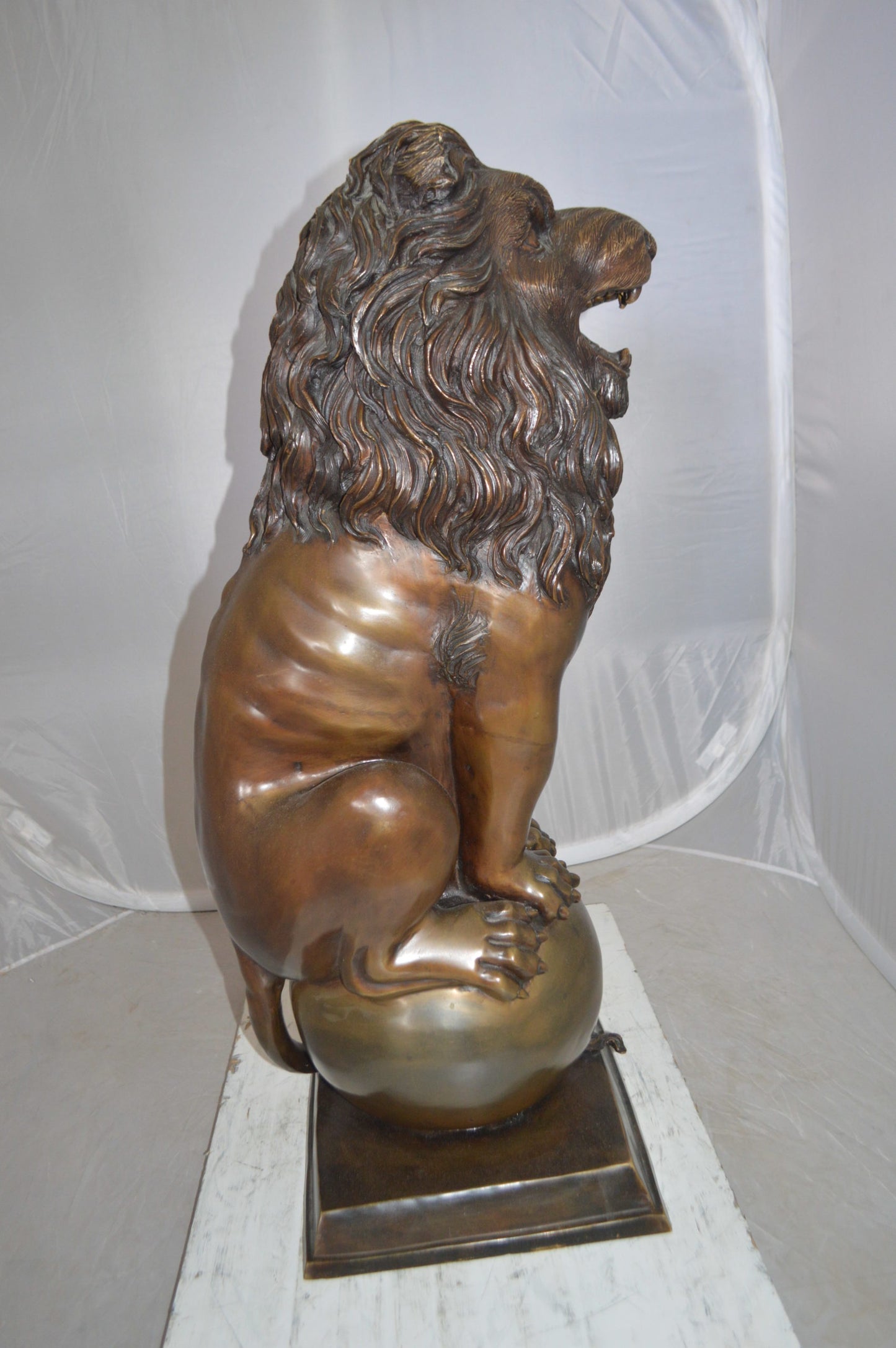 Pair of lions standing on balls, bronze statues - Size: 14"L x 16"W x 38"H.
