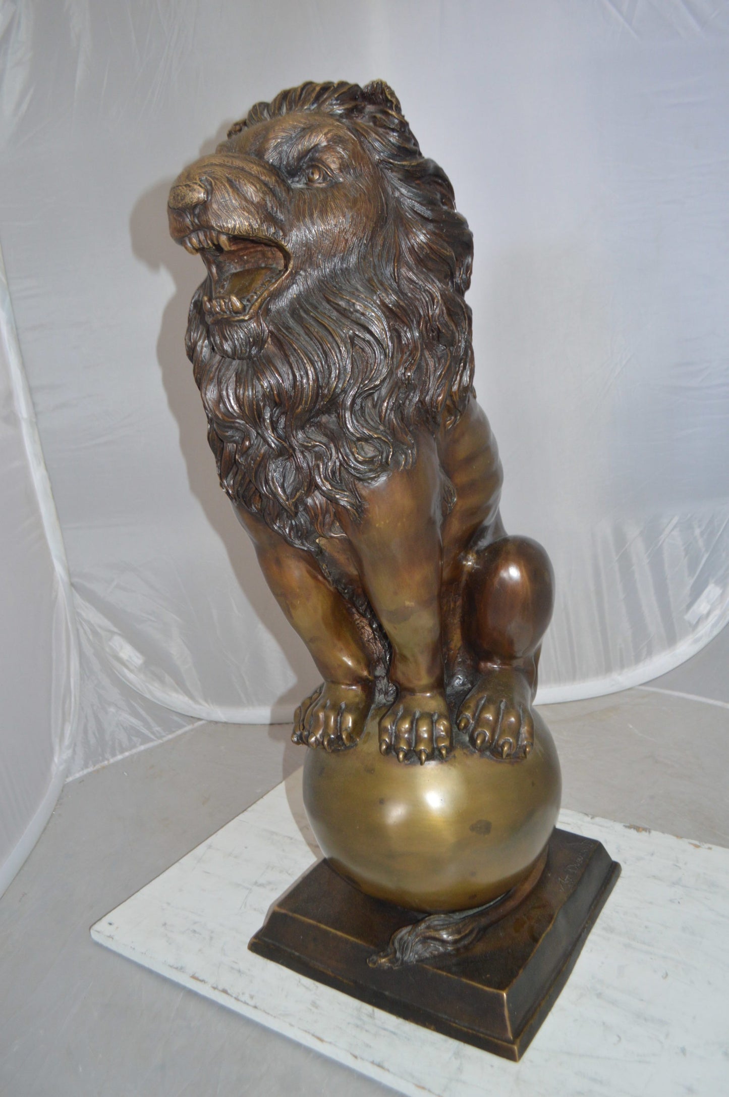 Pair of lions standing on balls, bronze statues - Size: 14"L x 16"W x 38"H.