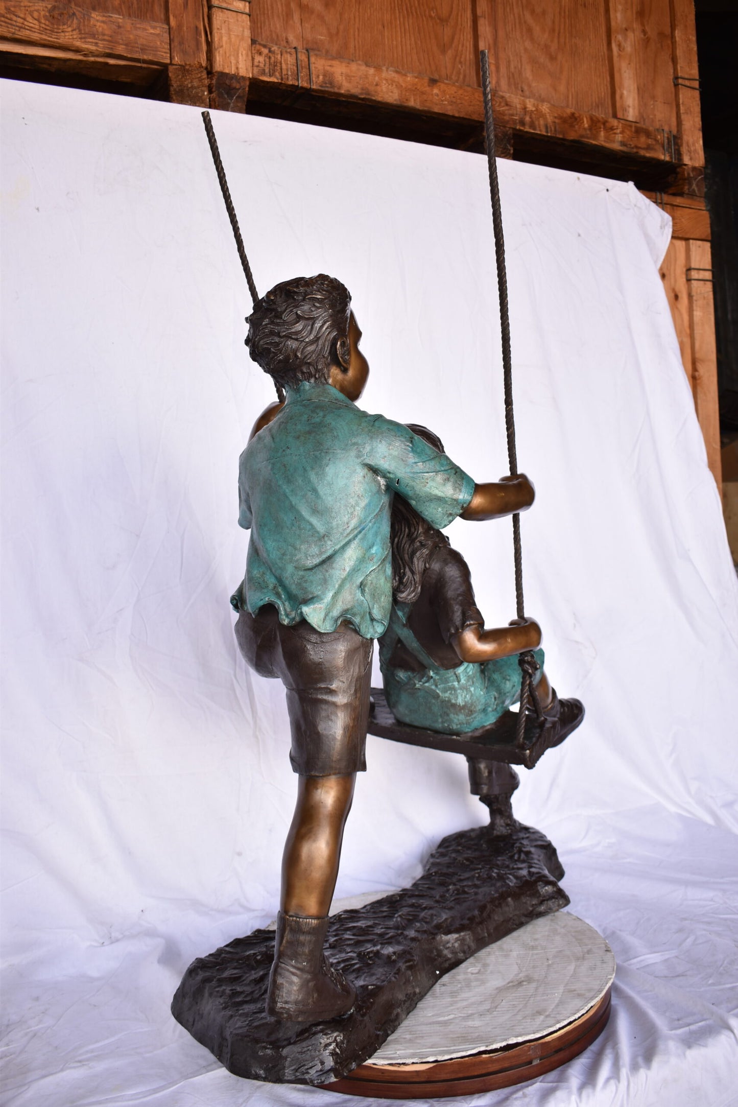 Boy and Girl Playing on a Swing bronze Statue - Size: 39"L x 17"W x 53"H.