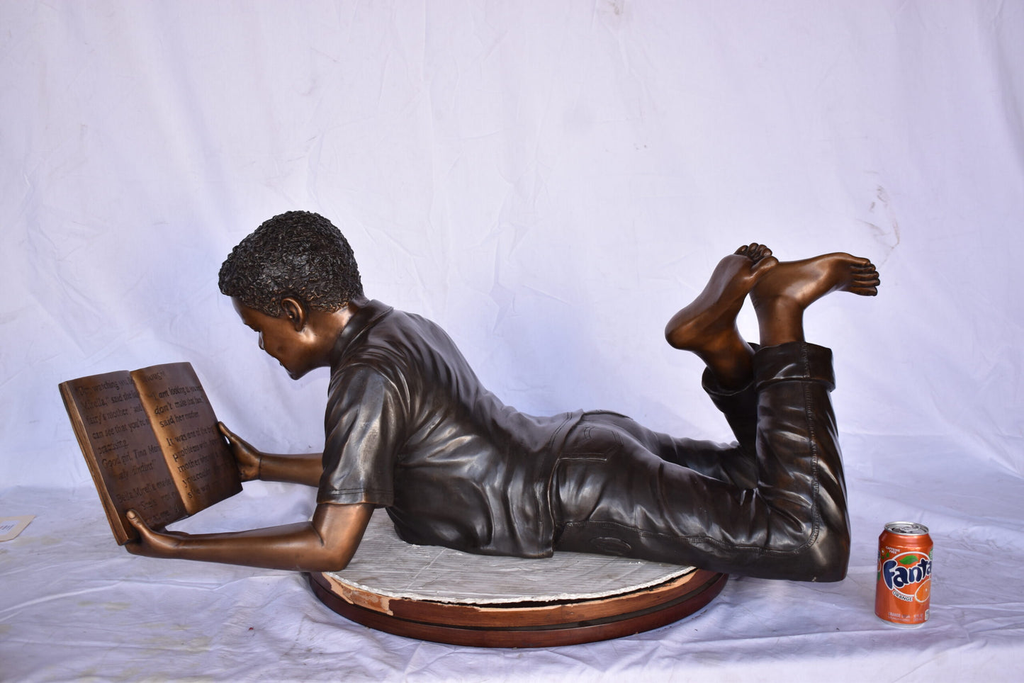 African American Boy reading a book bronze statue - Size: 42"L x 15"W x 19"H.