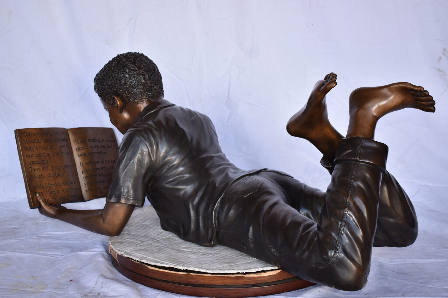 African American Boy reading a book bronze statue - Size: 42"L x 15"W x 19"H.