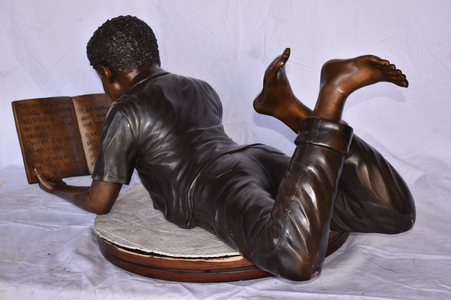 African American Boy reading a book bronze statue - Size: 42"L x 15"W x 19"H.