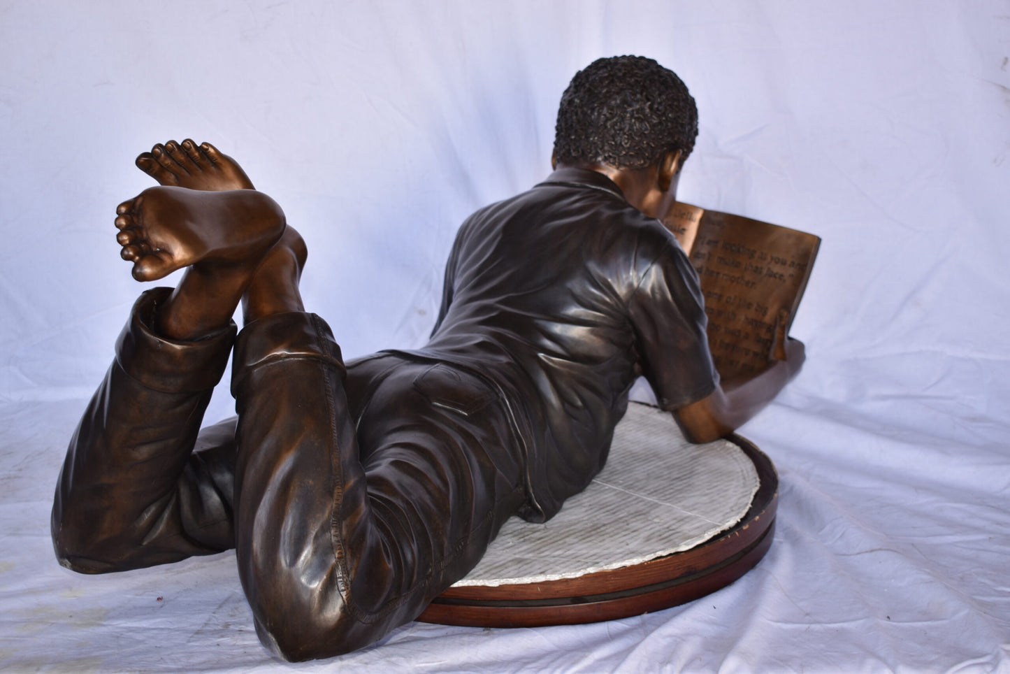 African American Boy reading a book bronze statue - Size: 42"L x 15"W x 19"H.