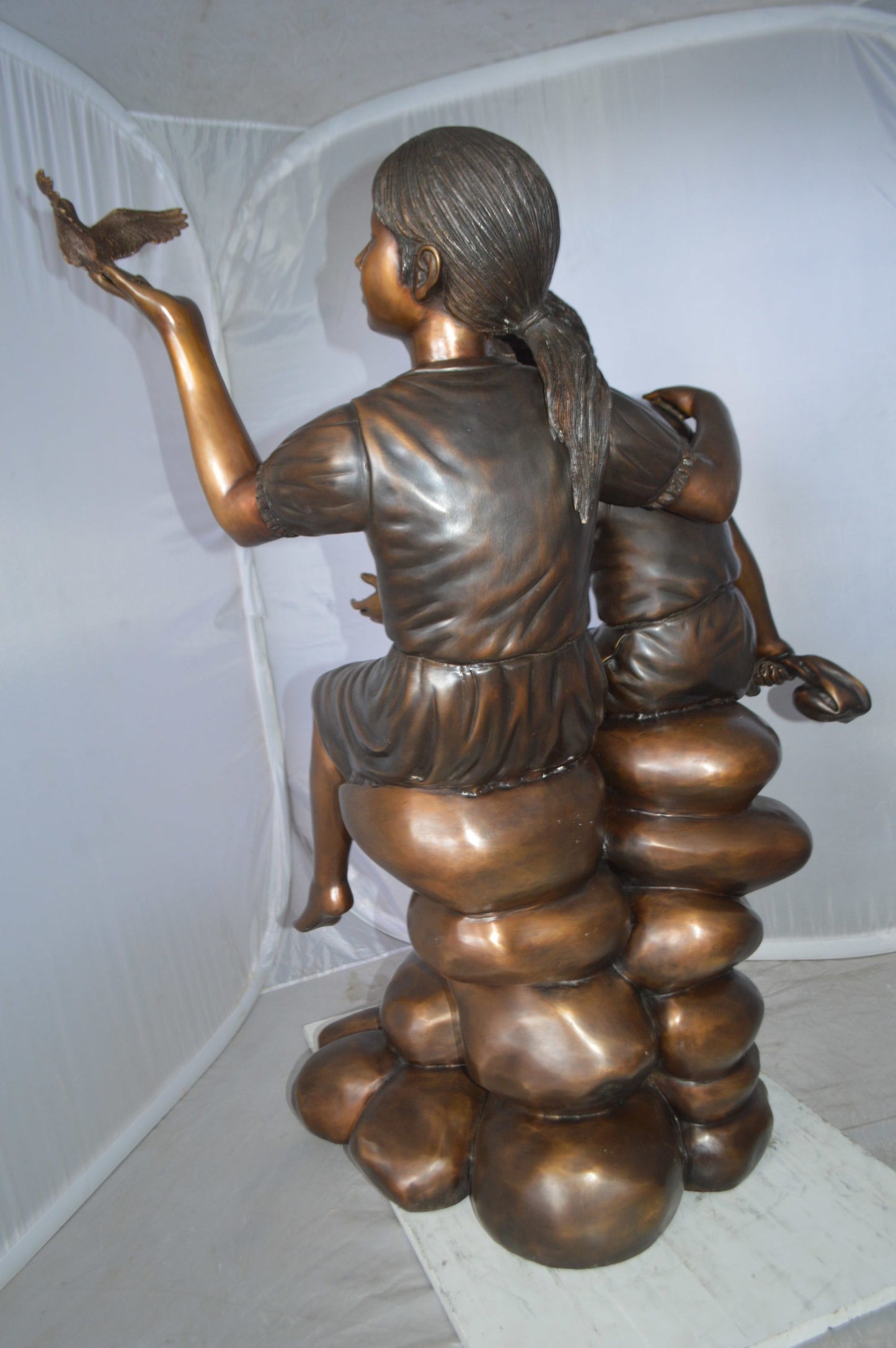 Two Kids on Rocks with a Bird Bronze Statue - Size: 36"L x 30"W x 44"H.