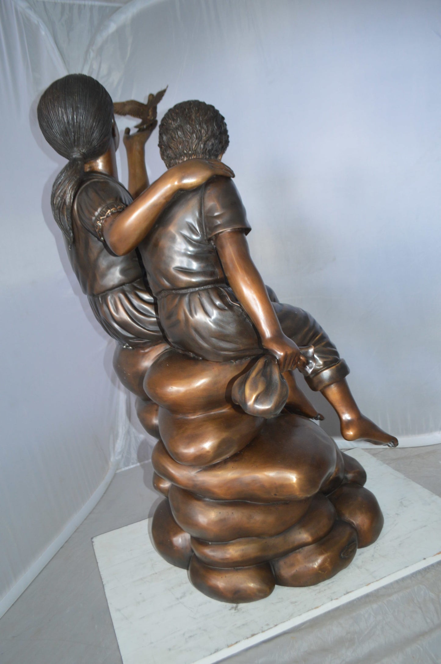 Two Kids on Rocks with a Bird Bronze Statue - Size: 36"L x 30"W x 44"H.