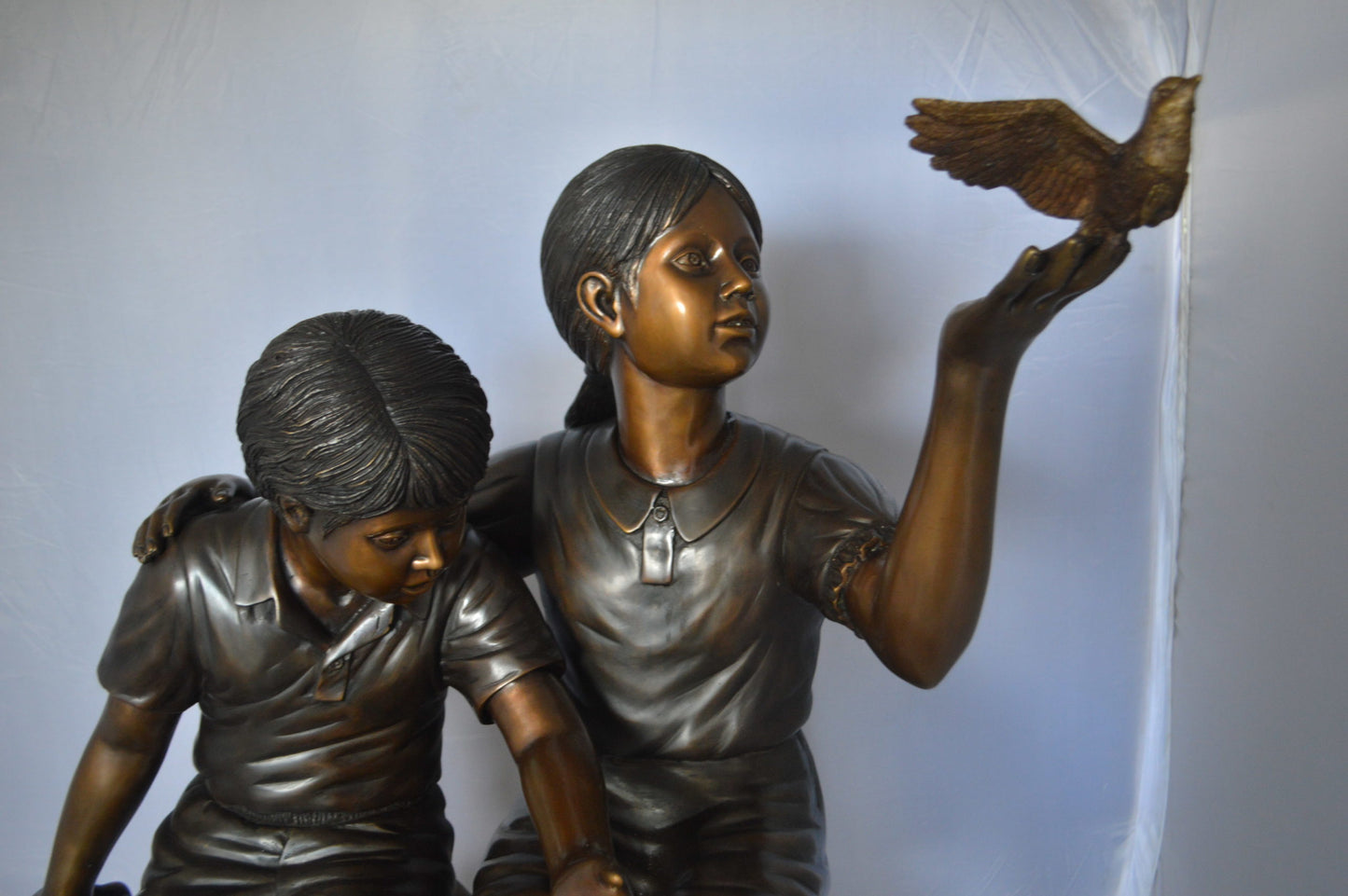 Two Kids on Rocks with a Bird Bronze Statue - Size: 36"L x 30"W x 44"H.