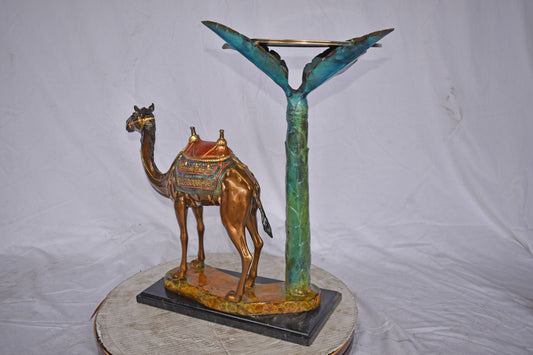 Camel Standing Under A Palm Tree Bronze Statue - Size: 20"L x 29"W x 25"H.