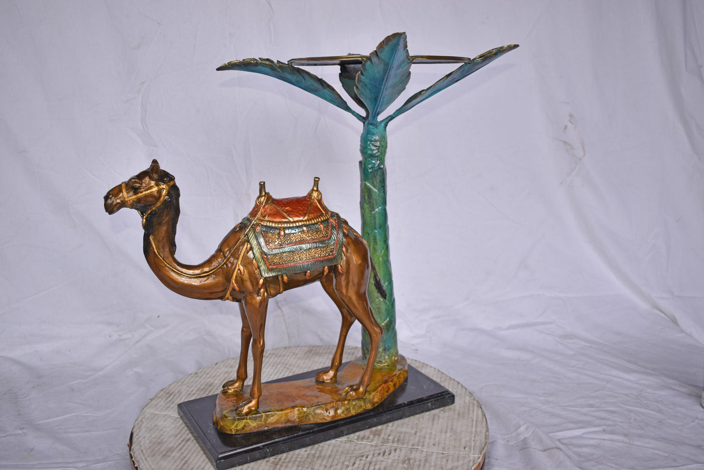 Camel Standing Under A Palm Tree Bronze Statue - Size: 20"L x 29"W x 25"H.