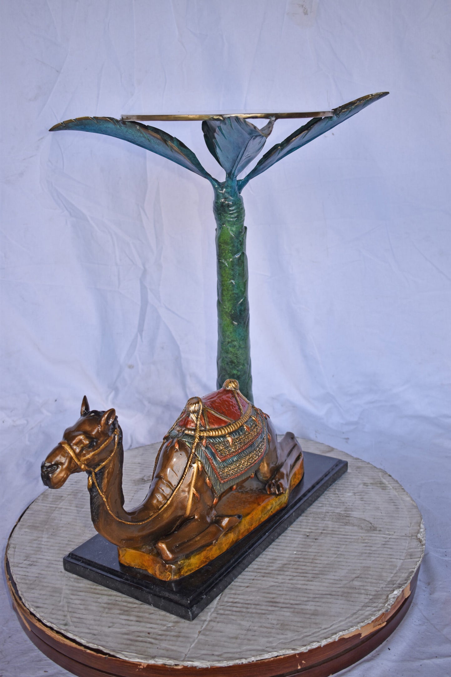 Camel Sitting Under A Palm Tree Bronze Statue - Size: 17"L x 27"W x 23"H.