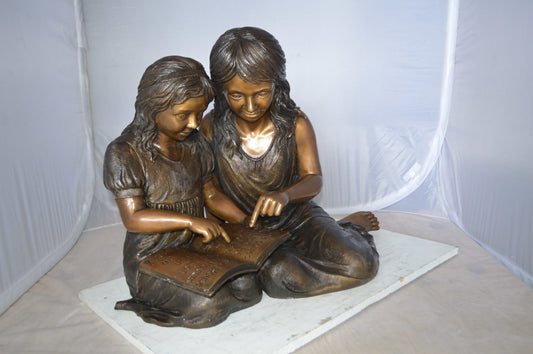 Two Girls Reading a Book Bronze Statue -  Size: 33"L x 21"W x 23"H.