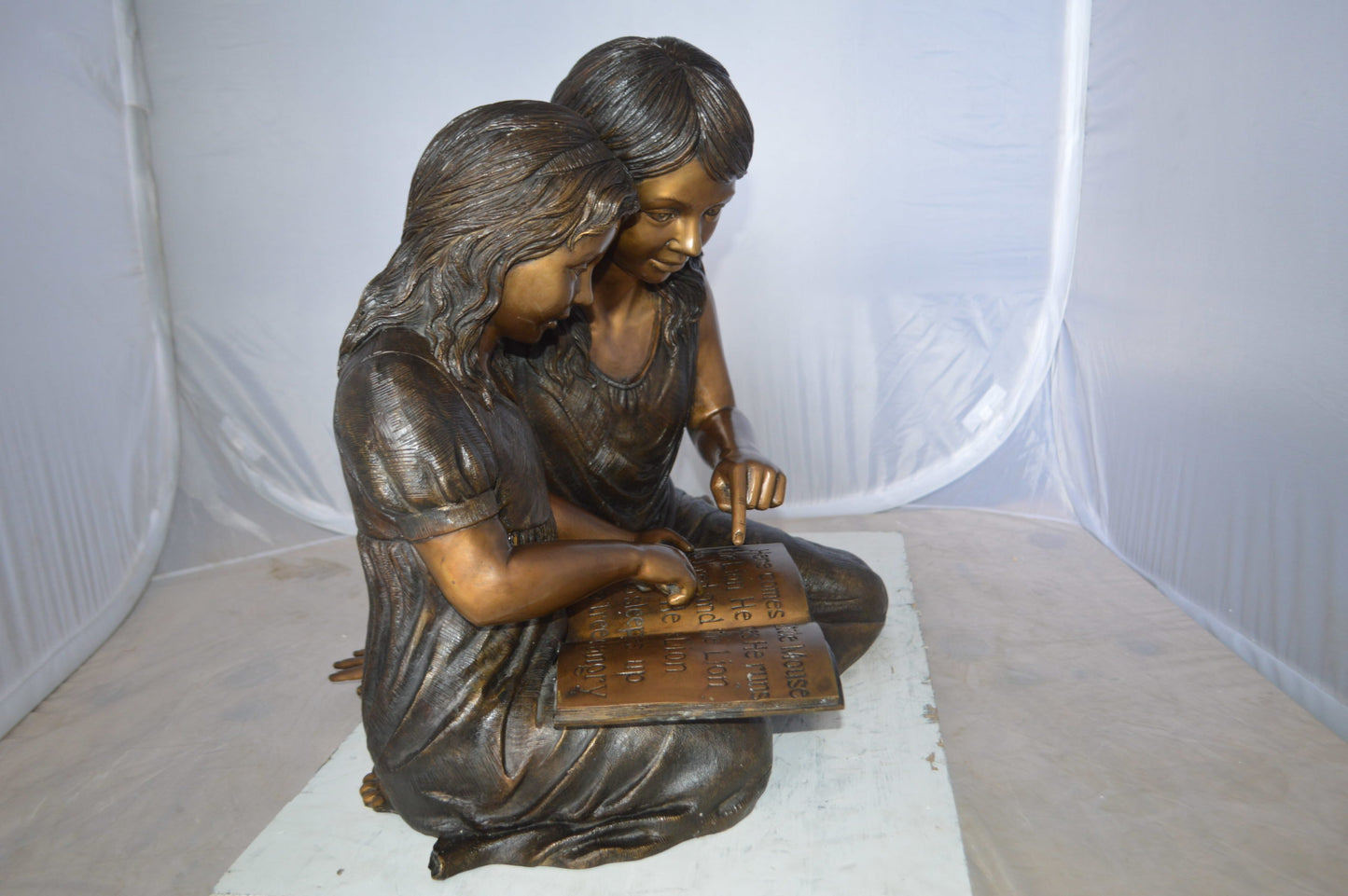 Two Girls Reading a Book Bronze Statue - Size: 33"L x 21"W x 23"H.