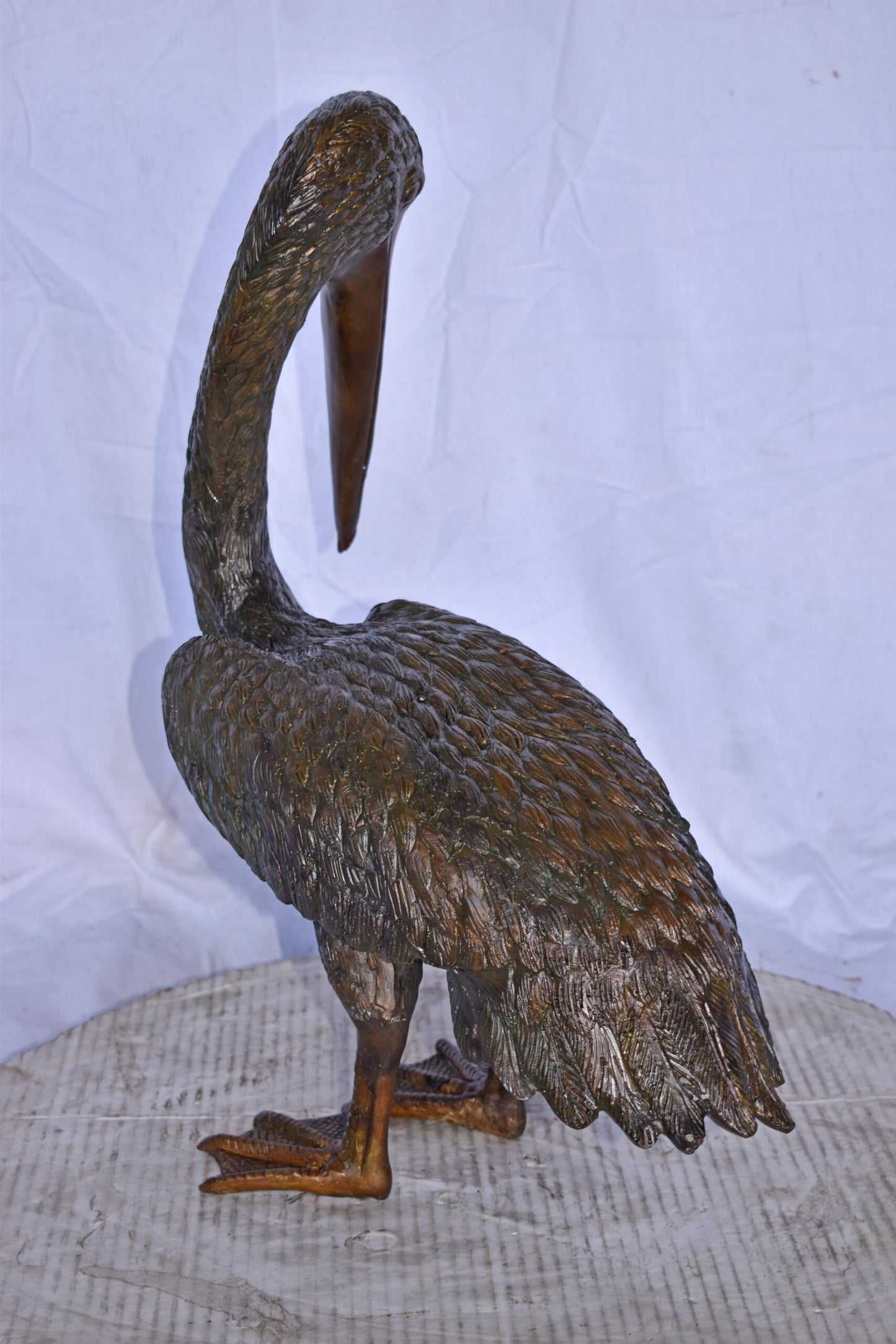 Pelican Standing and Looking Down Bronze Statue - Size: 20"L x 8"W x 22"H.