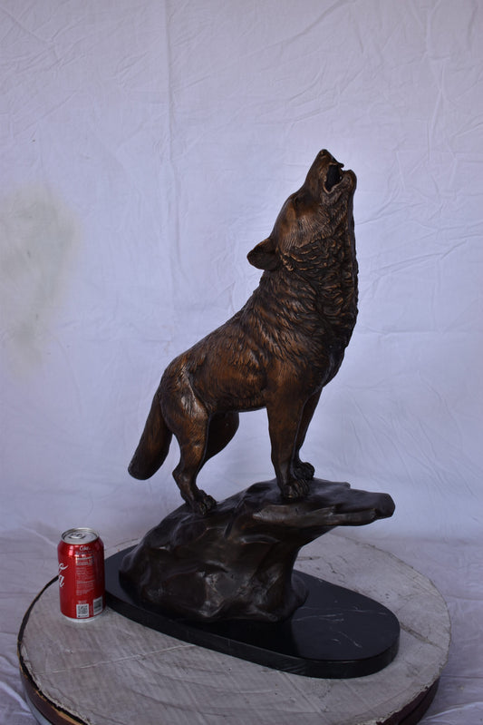Howling Wolf at Edge of a Cliff Bronze Statue - Size: 9"L x 20"W x 26"H.