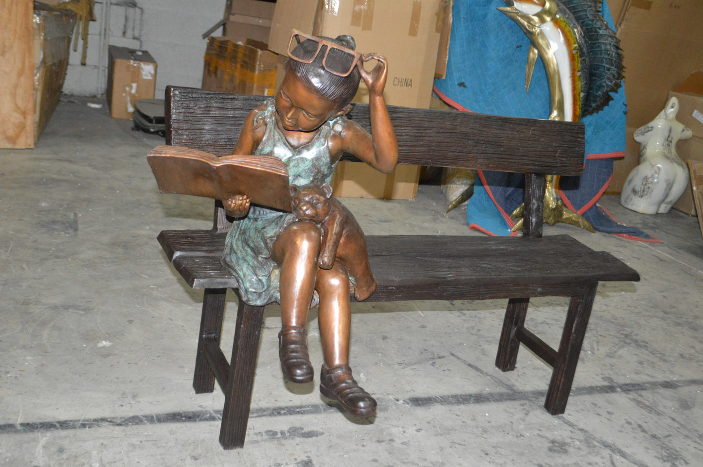Girl with Glasses on Bench Bronze Statue - Size: 43"L x 20"W x 36"H.