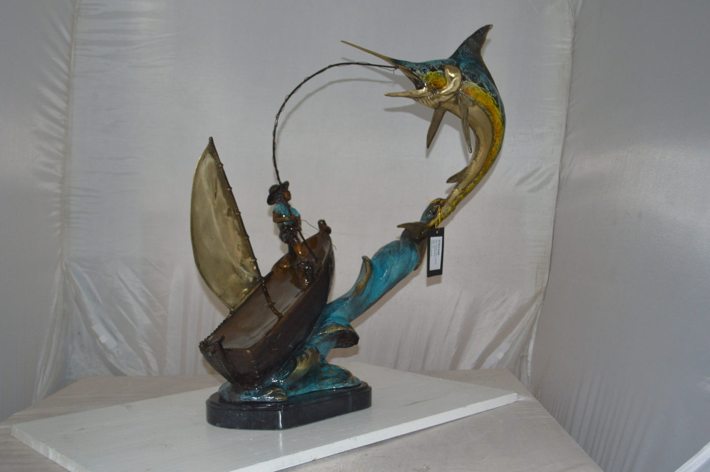 Old Man Fishing a Large Catch Bronze Statue - Size: 27"L x 13"W x 30"H.