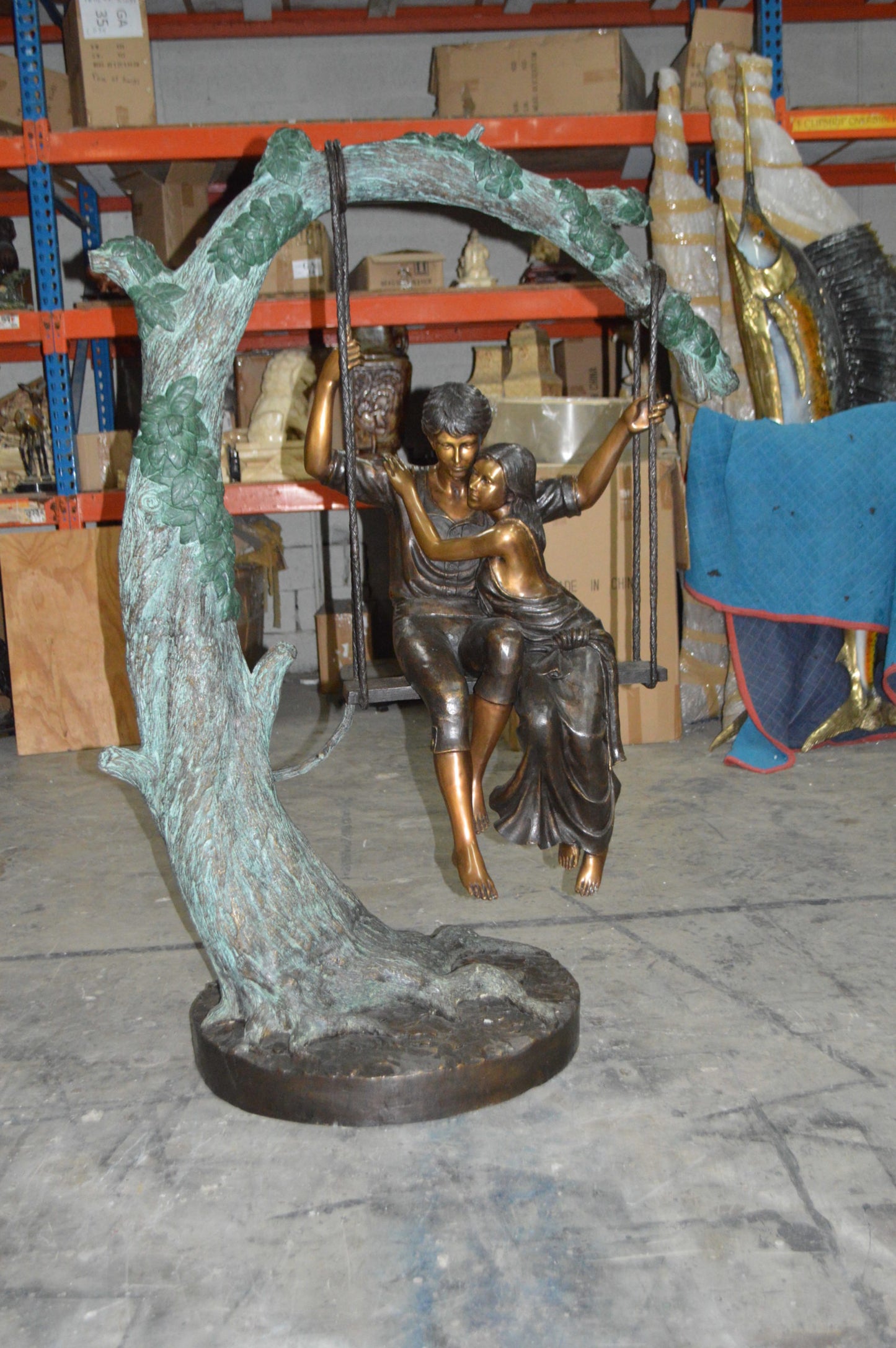 Lovers on a Swing Bronze Statue - Size: 48"L x 32"W x 64"H.