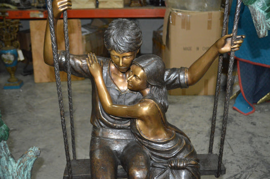 Lovers on a Swing Bronze Statue - Size: 48"L x 32"W x 64"H.