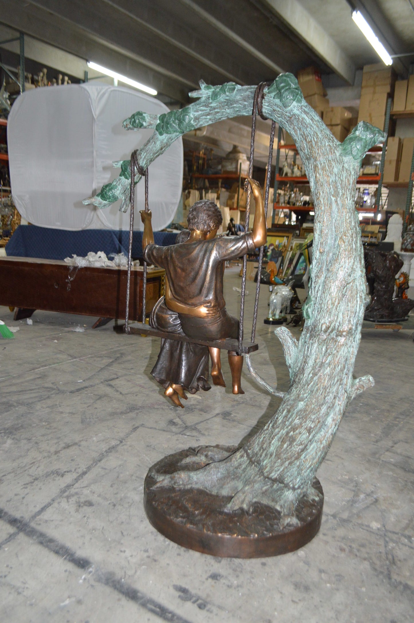 Lovers on a Swing Bronze Statue - Size: 48"L x 32"W x 64"H.