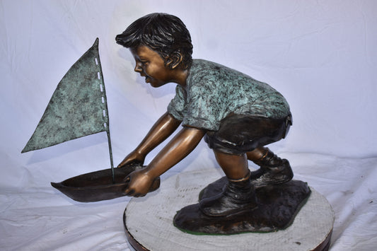 Boy Sends His Toy Boat on The Water Bronze Statue - Size: 16"L x 33"W x 24"H.
