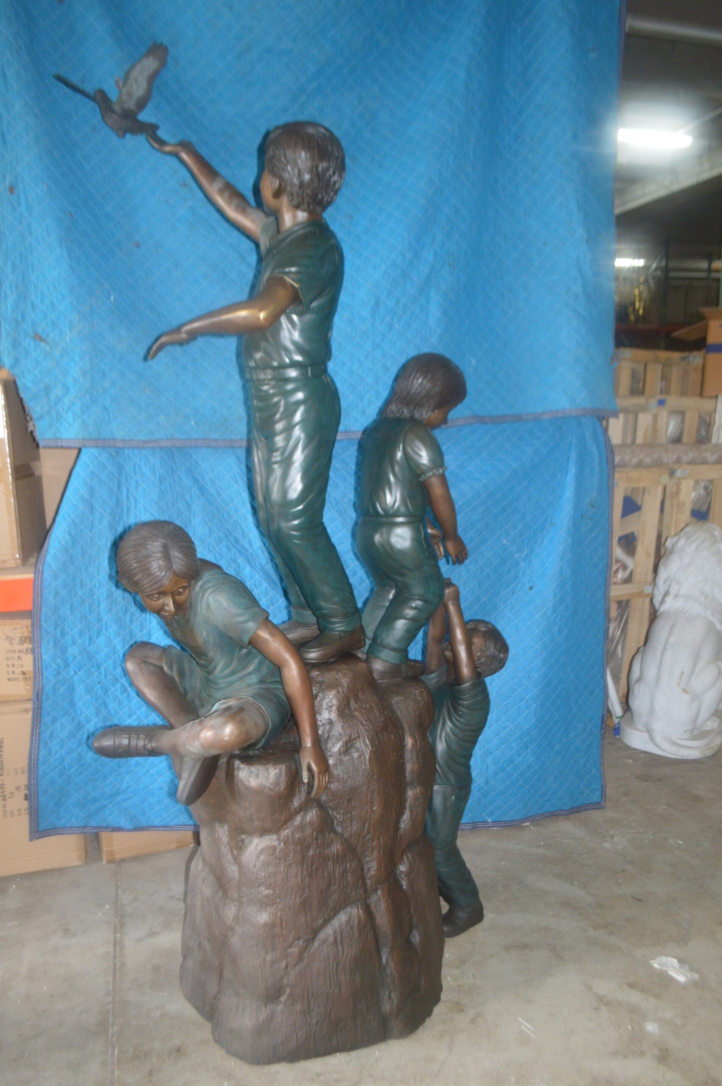 Four Kids Playing on a Rock Bronze Statue - Size: 49"L x 26"W x 89"H.