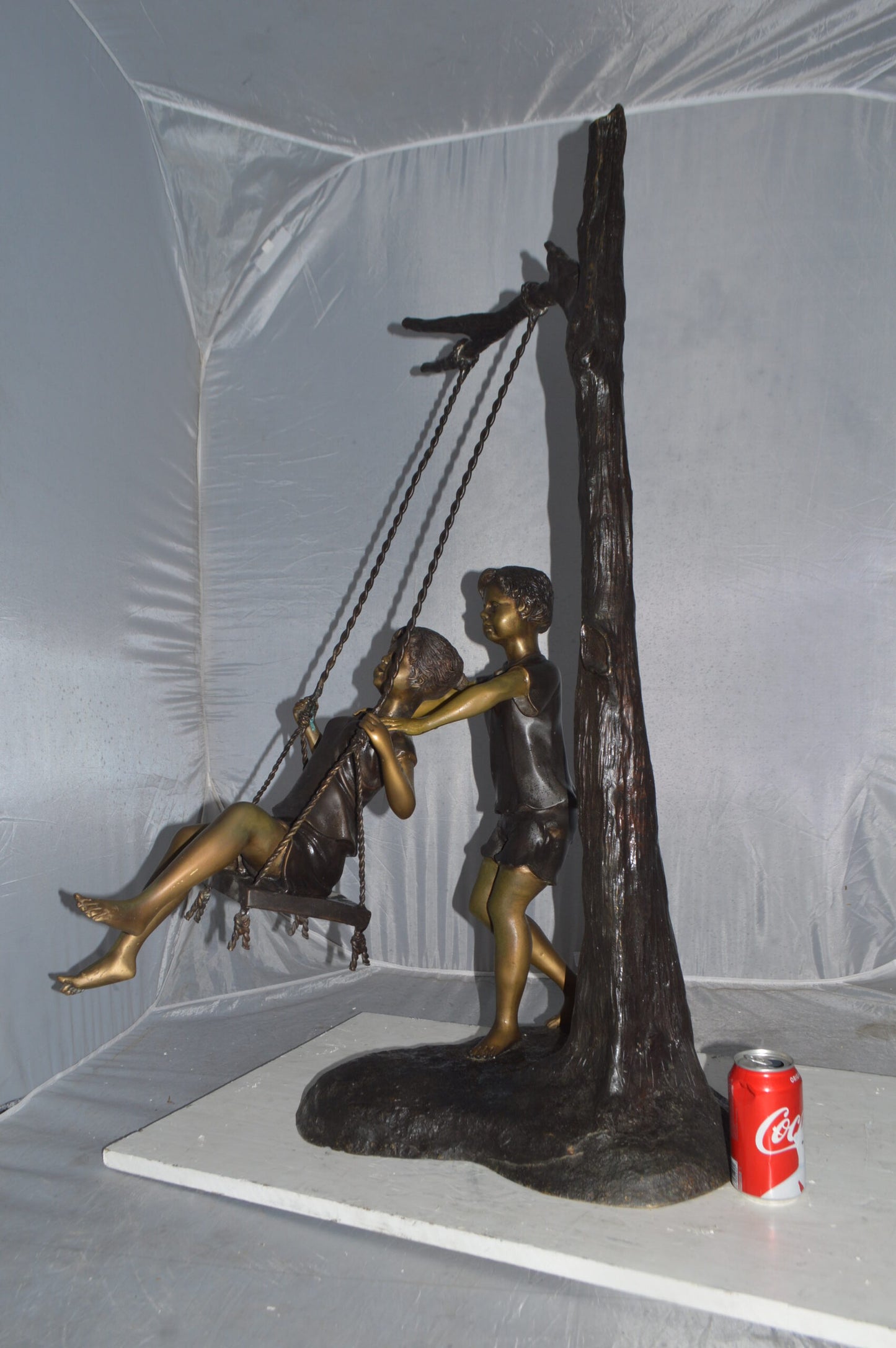 Kids Playing on a Swing bronze Statue - Size: 22"L x 25"W x 43"H.