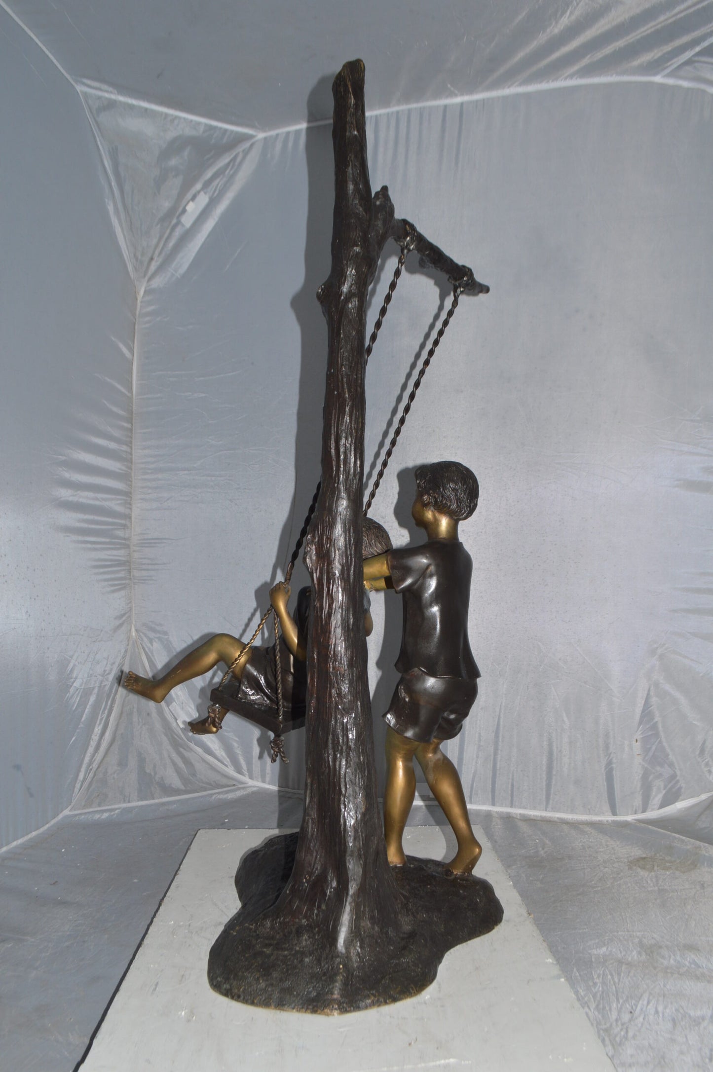 Kids Playing on a Swing bronze Statue - Size: 22"L x 25"W x 43"H.