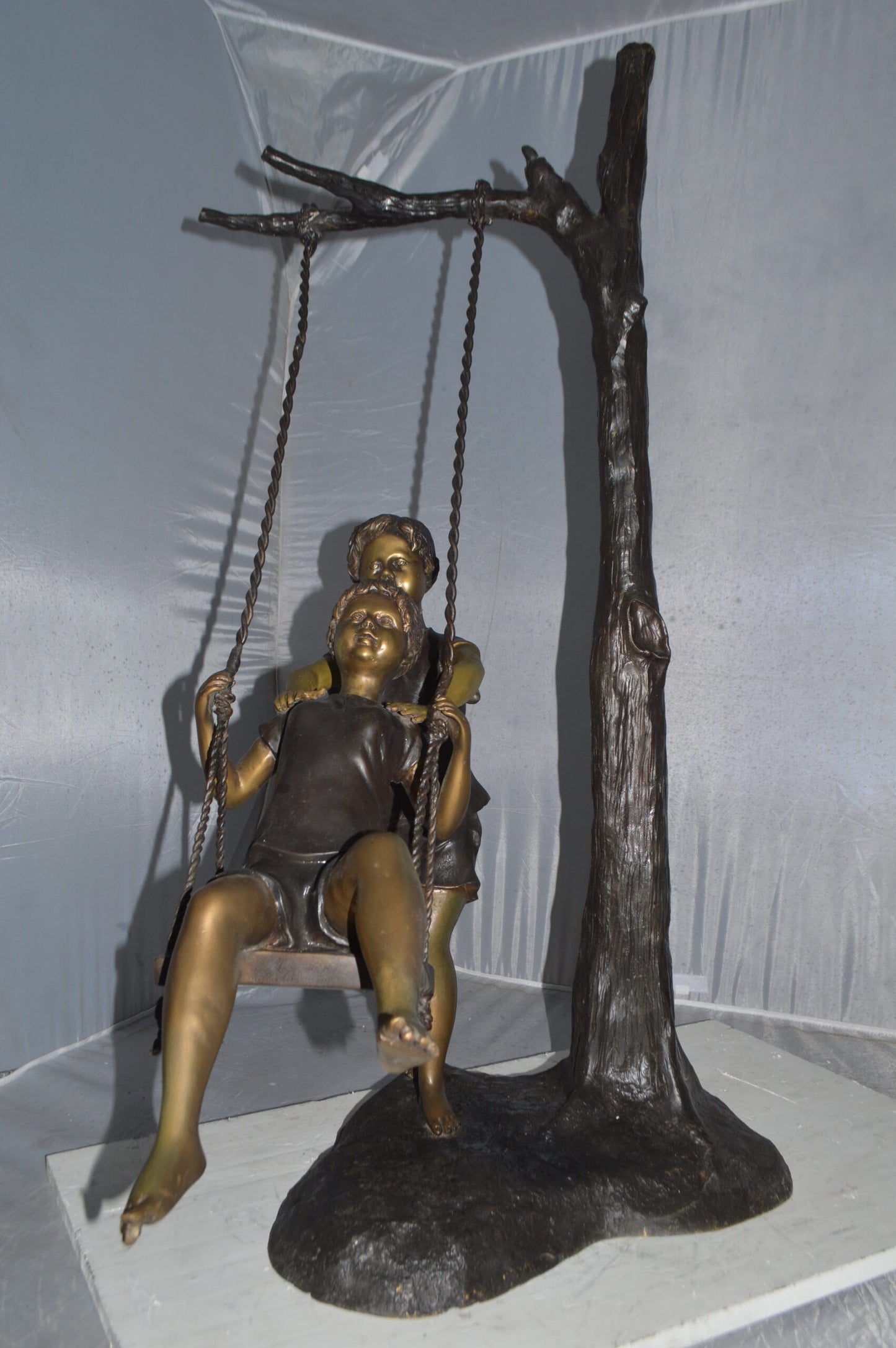 Kids Playing on a Swing bronze Statue - Size: 22"L x 25"W x 43"H.
