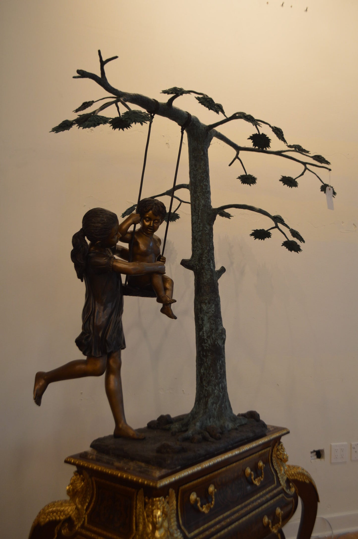 Swing Set Under A Three Bronze Statue - Size: 60"L x 33"W x 60"H.