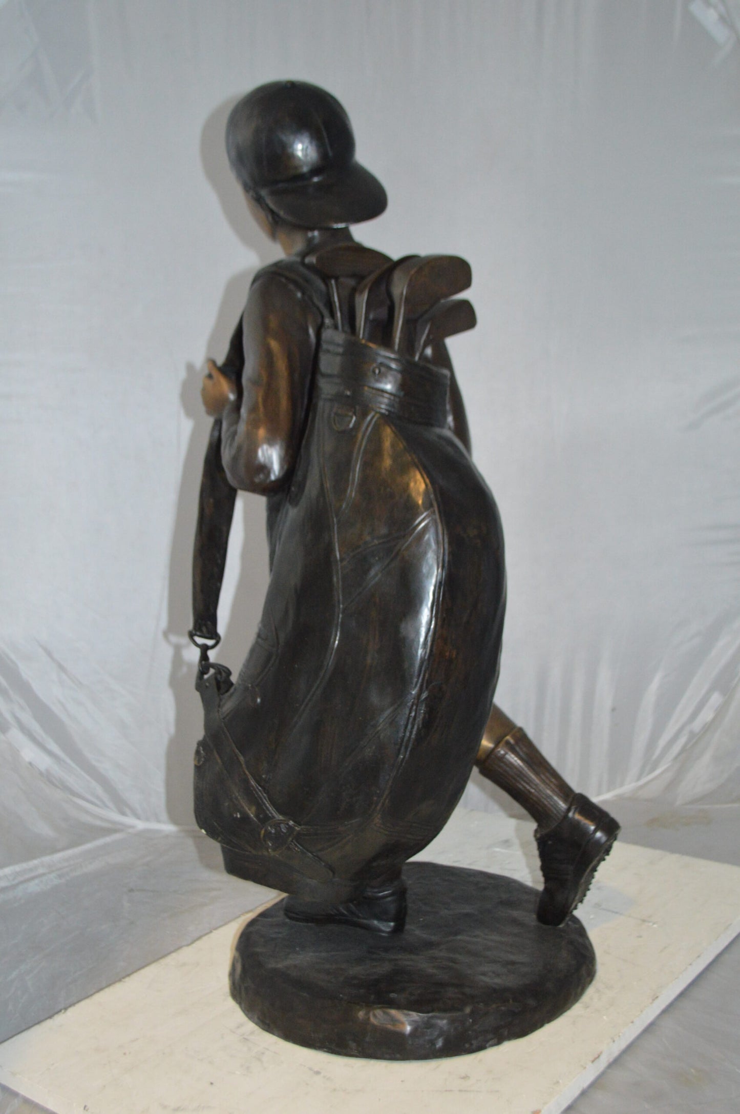 Boy Carrying A Golf Bag Bronze Statue - Size: 15"L x 15"W x 38"H.