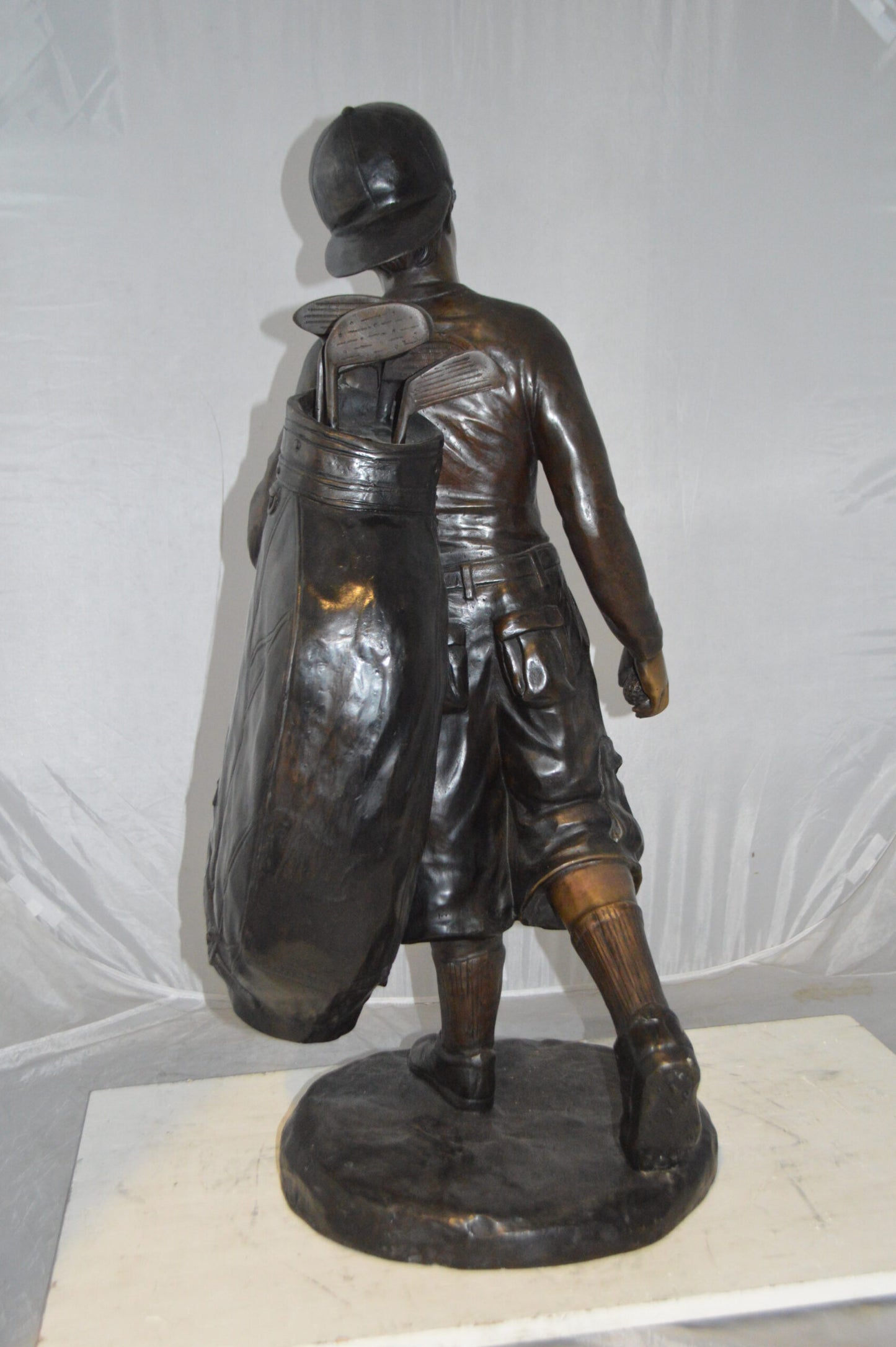 Boy Carrying A Golf Bag Bronze Statue - Size: 15"L x 15"W x 38"H.